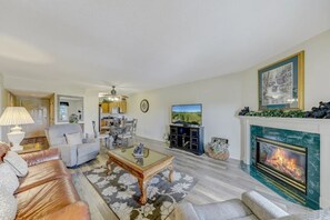 Una sala de estar con chimenea, televisor y comedor.