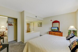 A hotel room with a bed, a television, a dresser, a mirror, and a door leading to a bathroom. - Two Bedroom, Two bathroom Condo in Pigeon Forge| Near Dollywood| Sleeps 6 (Pigeon Forge)