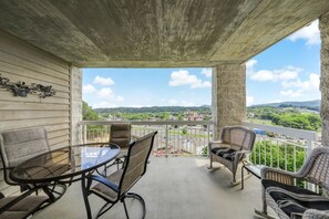 A balcony with a table and chairs, a view of a green landscape, and a clear sky. - Two Bedroom, Two bathroom Condo in Pigeon Forge| Near Dollywood| Sleeps 6 (Pigeon Forge)