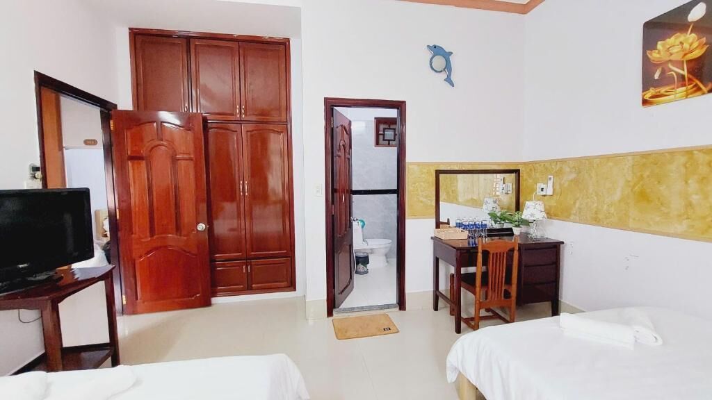 Une chambre d’hôtel comprenant un lit, un bureau avec une chaise, une télévision et une armoire.