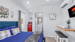 A bedroom with a bed, a desk, and a kitchenette. - Hill Country Views | Canyon Lake Retreat (Canyon Lake)