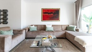 A living room with a glass coffee table, two sofas, a painting, and a window with curtains. - Apartment in Elviria With Terrace, Marbella (Marbella)