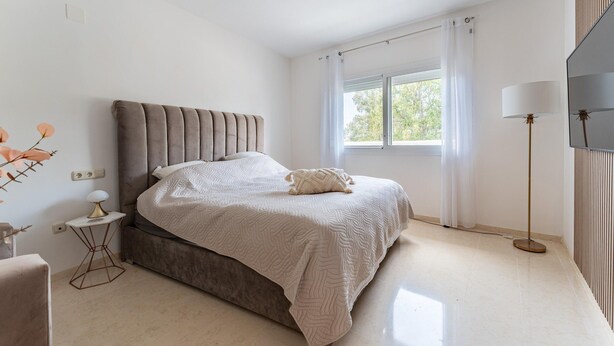 A bedroom with a bed, a bedside table, a lamp, and a window with curtains. - Apartment in Elviria With Terrace, Marbella (Marbella)