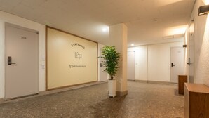 A hallway with a potted plant, a wall with a 'STAY+WAVE' sign, and doors numbered 208 and 204. - STAYV Jang-an (Seoul)