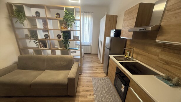A modern kitchen with a built-in oven, a stainless steel refrigerator, and a wooden countertop. - Nice newly renovated apartment with all amenities near the metro. (Milano)