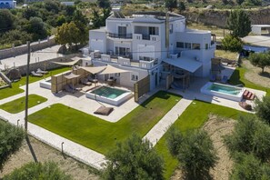 A modern two-story house with a swimming pool, outdoor seating, and a well-maintained garden. - Elaionas Luxe w/ Private Pool - No. 3 (Mastihari)