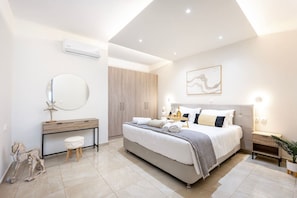 Une chambre moderne avec un grand lit, des tables de chevet, un miroir et une armoire.
