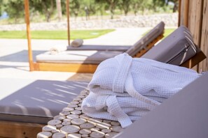 Une table de massage en bois, recouverte dâune serviette blanche, avec un repose-pied en bois.