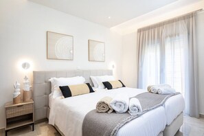 Ein modernes Schlafzimmer mit Bett, Nachttischen und Kunstwerken.