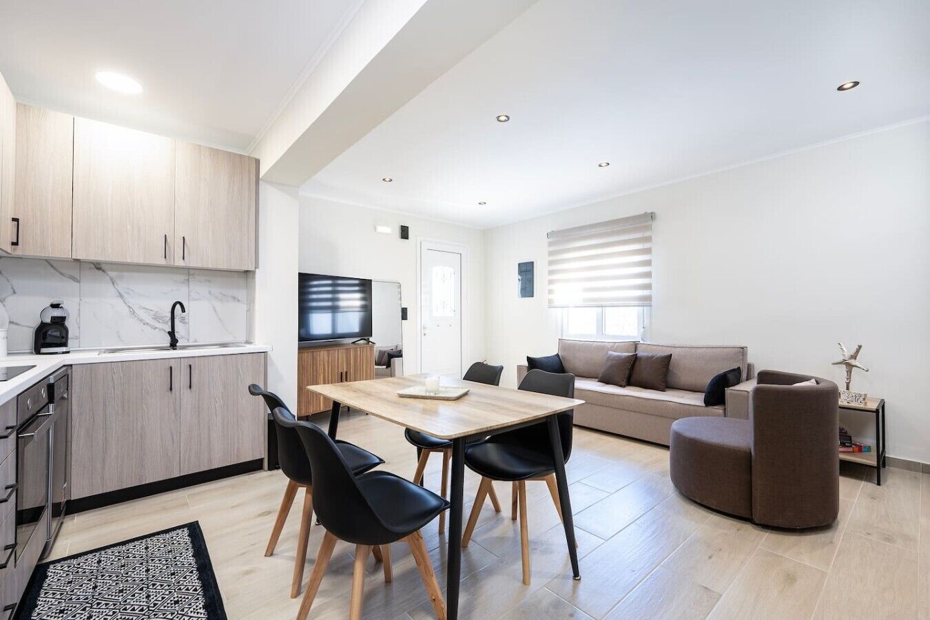 Un appartement moderne comprenant une cuisine, un coin repas et un salon.