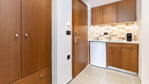 A modern kitchen with wooden cabinets, a dishwasher, and a tiled backsplash.