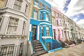 A row of terraced houses with distinct architectural styles and colors. - The Notting Hill Blue Palace (Greater London)