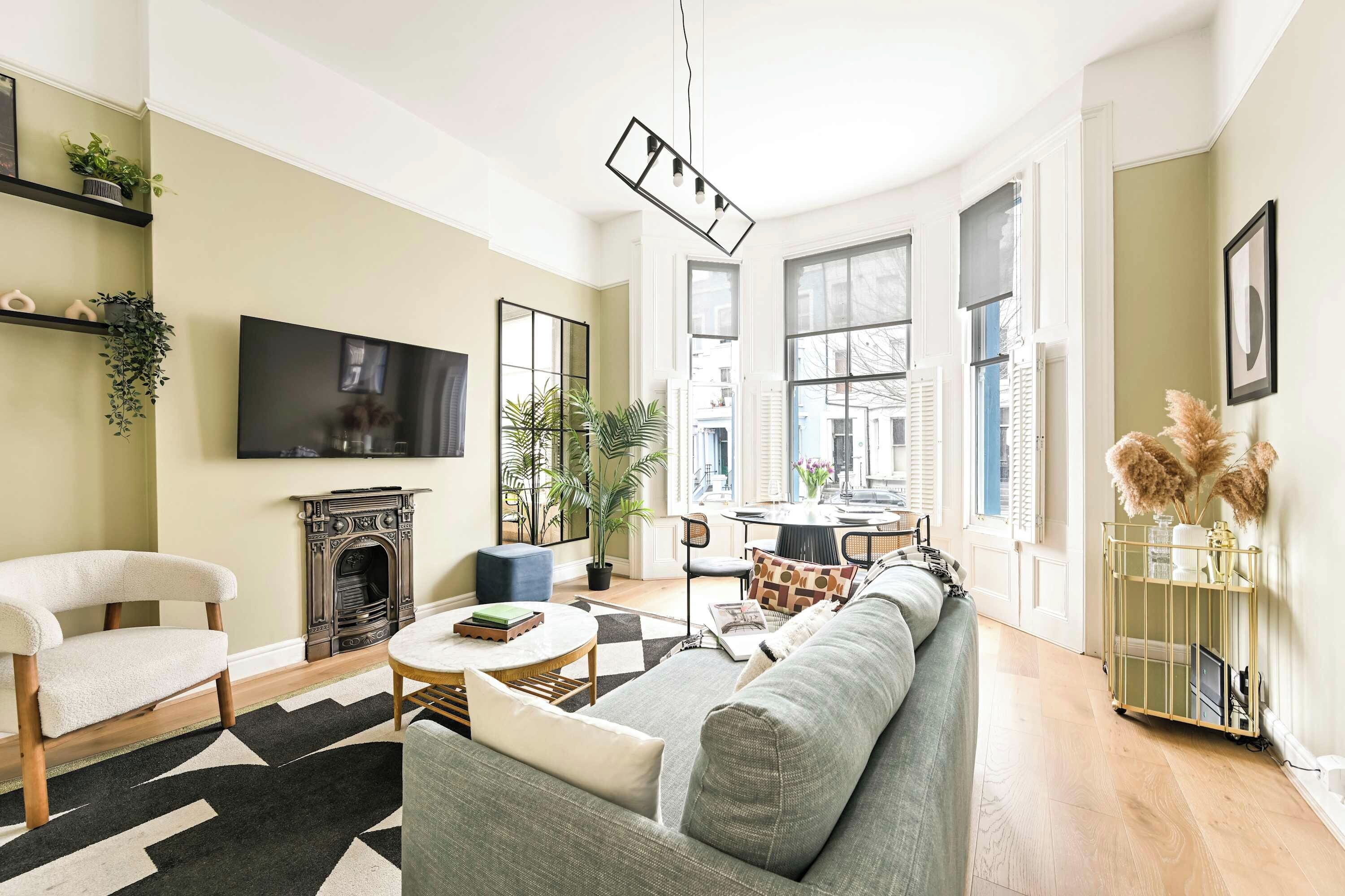 Ein Wohnzimmer mit Sofa, Fernseher, Kamin und Essbereich.