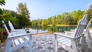 Terraza al aire libre con vista a un lago y árboles.