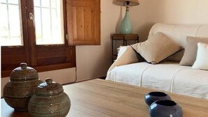 Et værelse med et træbord, en sofa og en lampe.