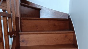 A wooden staircase with a handrail on the left.