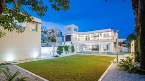 A modern hotel with a spacious outdoor area, a swimming pool, and a well-maintained lawn. - Luxury 5BR Villa Jomtien - Pool, Sports & Karaoke Close to the beach of pattaya (เมืองพัทยา)