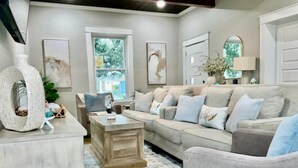 A living room with a sofa, coffee table, and a decorative vase. - Coastal Cove Near Beach (Galveston)