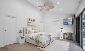 A bedroom with a bed, a desk, a chair, a ceiling fan, and a window. - Luxury Gold Coast Acreage Retreat | Pool, Spa, Sauna & Fire Pit (Nerang)