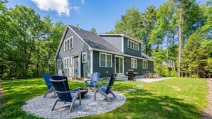 A two-story house with a patio area featuring outdoor seating. - Van Duyne North Airy Escape (Ogunquit)