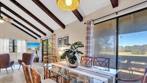 A dining area with a glass table, wicker chairs, and a potted plant. - Heavenly Par-adise 2‑Bedroom Villa Overlooking the Golf Course Seascape (Miramar Beach)