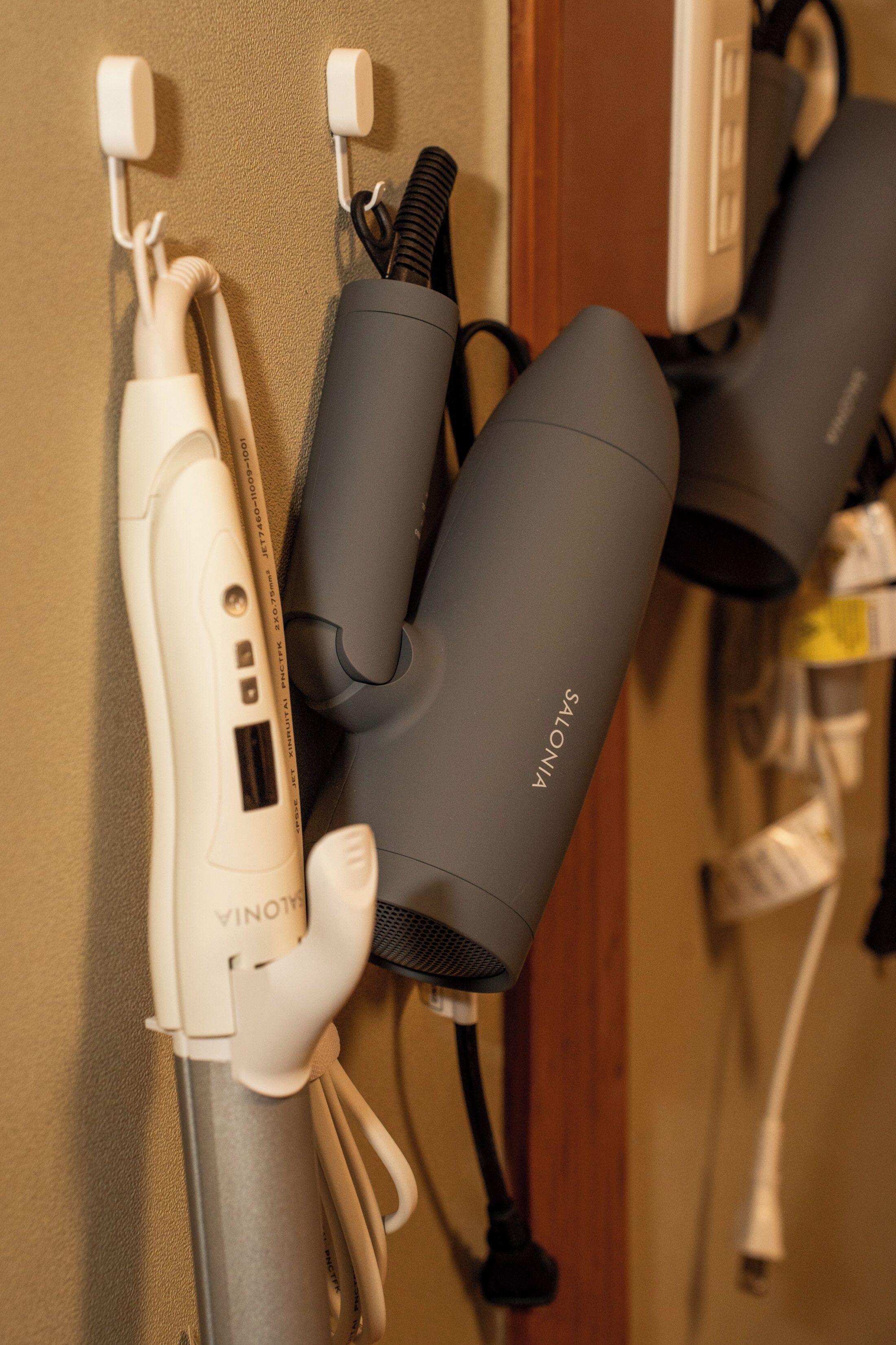 A wall-mounted hairdryer and a vacuum cleaner.