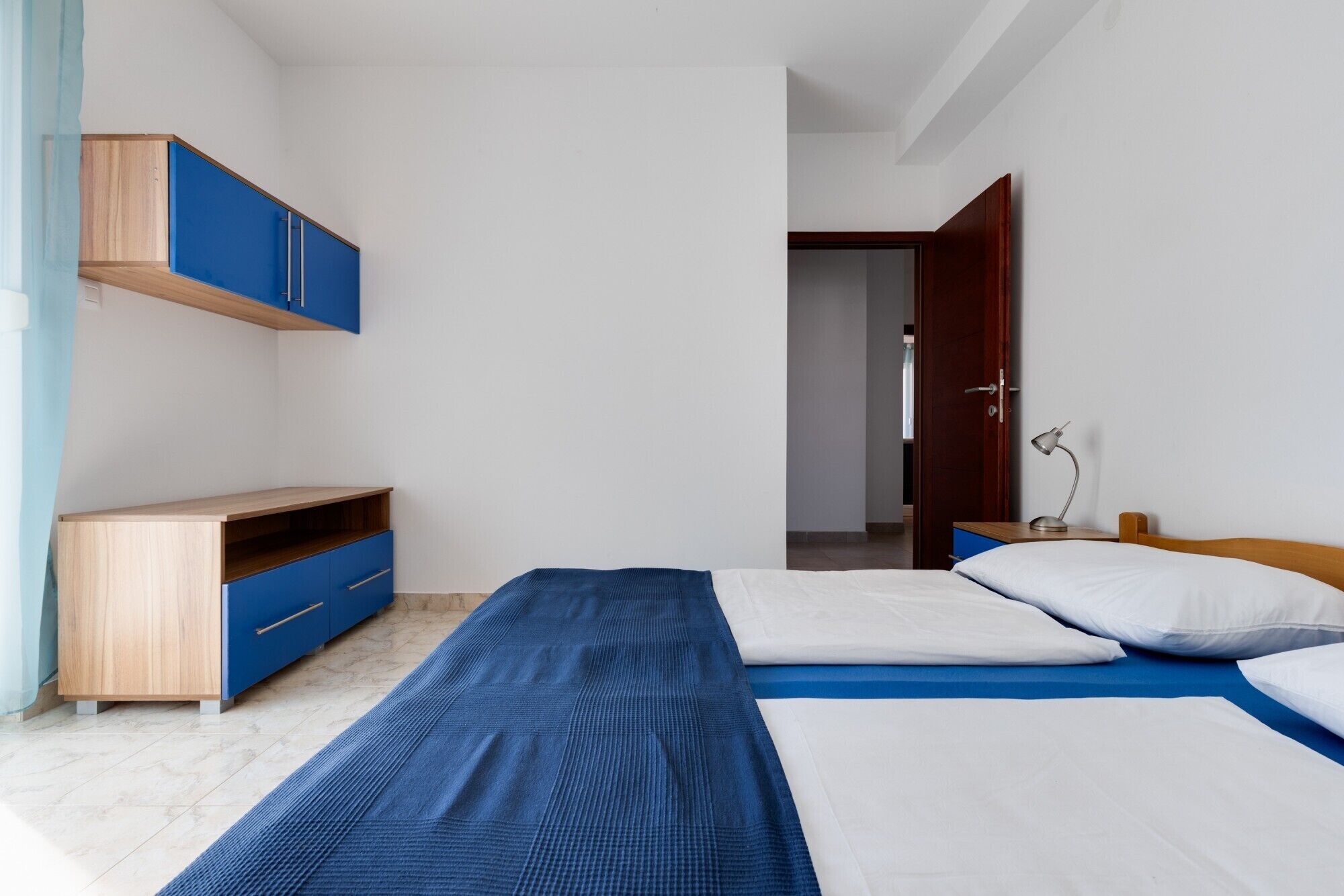Een slaapkamer met een bed, bureau en kledingkast.