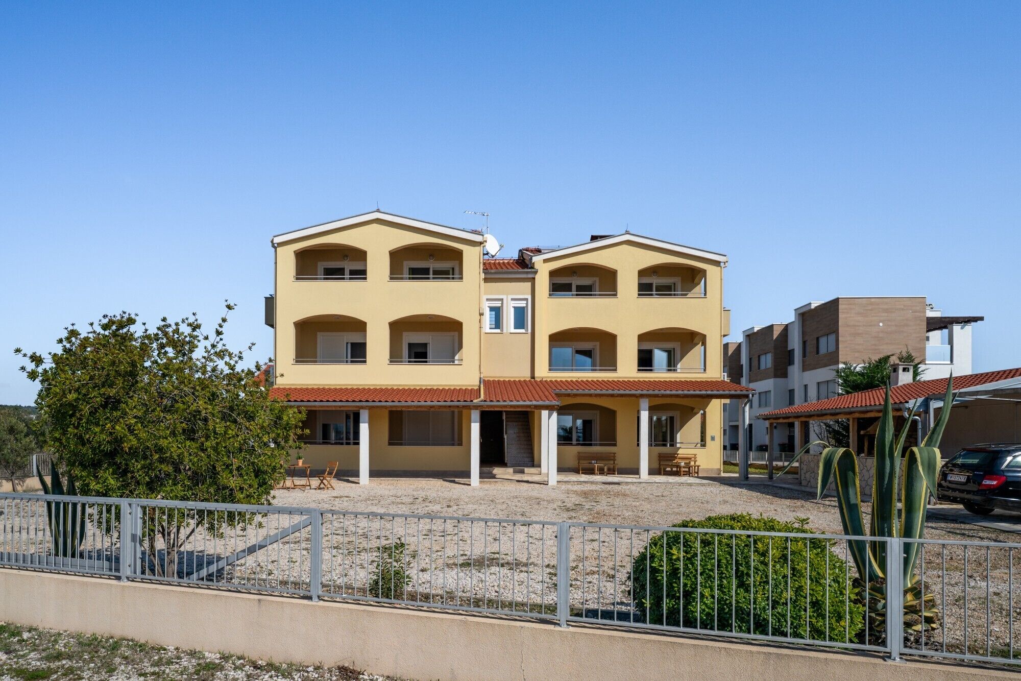 Un bâtiment à deux étages, doté d’un toit plat et d’un balcon.