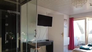 Makuuhuoneessa on sänky, työpöytä, jossa on tietokone, televisio ja lasiliukuovi, joka johtaa parvekkeelle.
