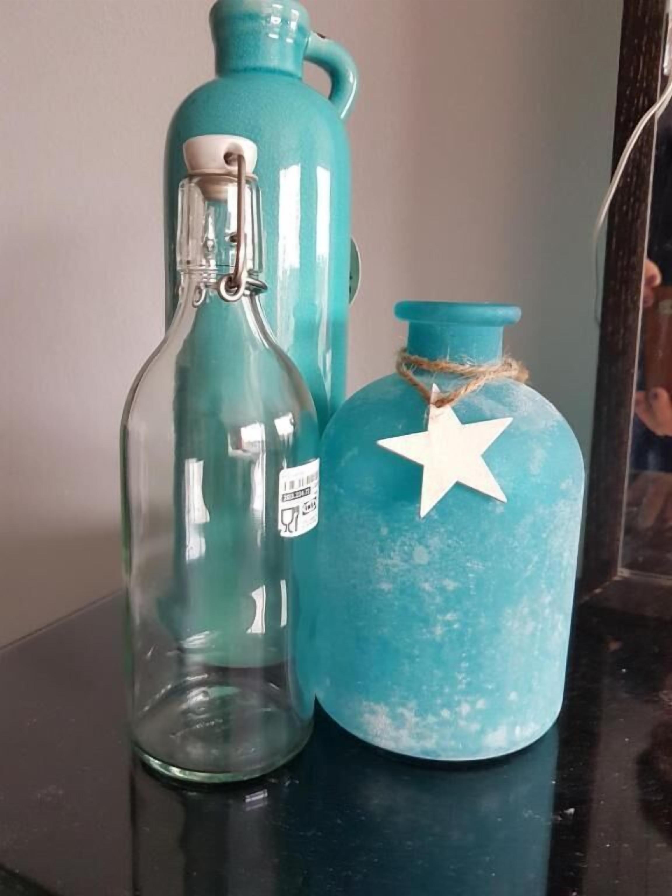 Two glass containers with labels, one clear and one blue, on a dark surface.