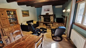 Uma sala de estar acolhedora com lareira, móveis de madeira e estante de livros.
