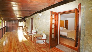 Un corridoio con pavimento in legno che conduce a una camera da letto con un letto, una sedia e un tavolo.