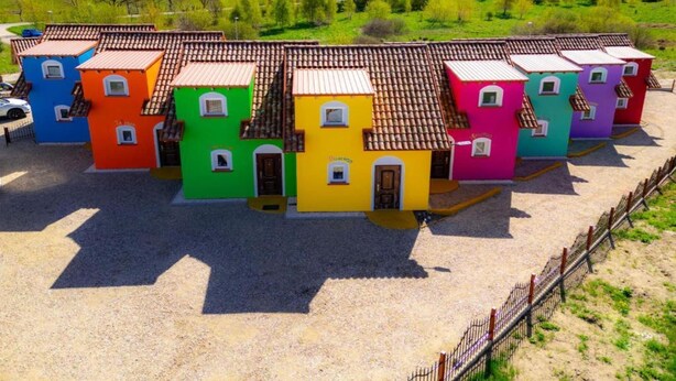 A row of colorful, single-story buildings with tiled roofs, arranged in a row. - Comfortable Mexican-style holiday home (Debina)