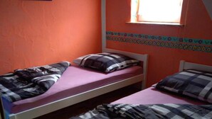 A room with two single beds, a window with a view, and a wall with a decorative border. - Comfortable Mexican-style holiday home (Debina)