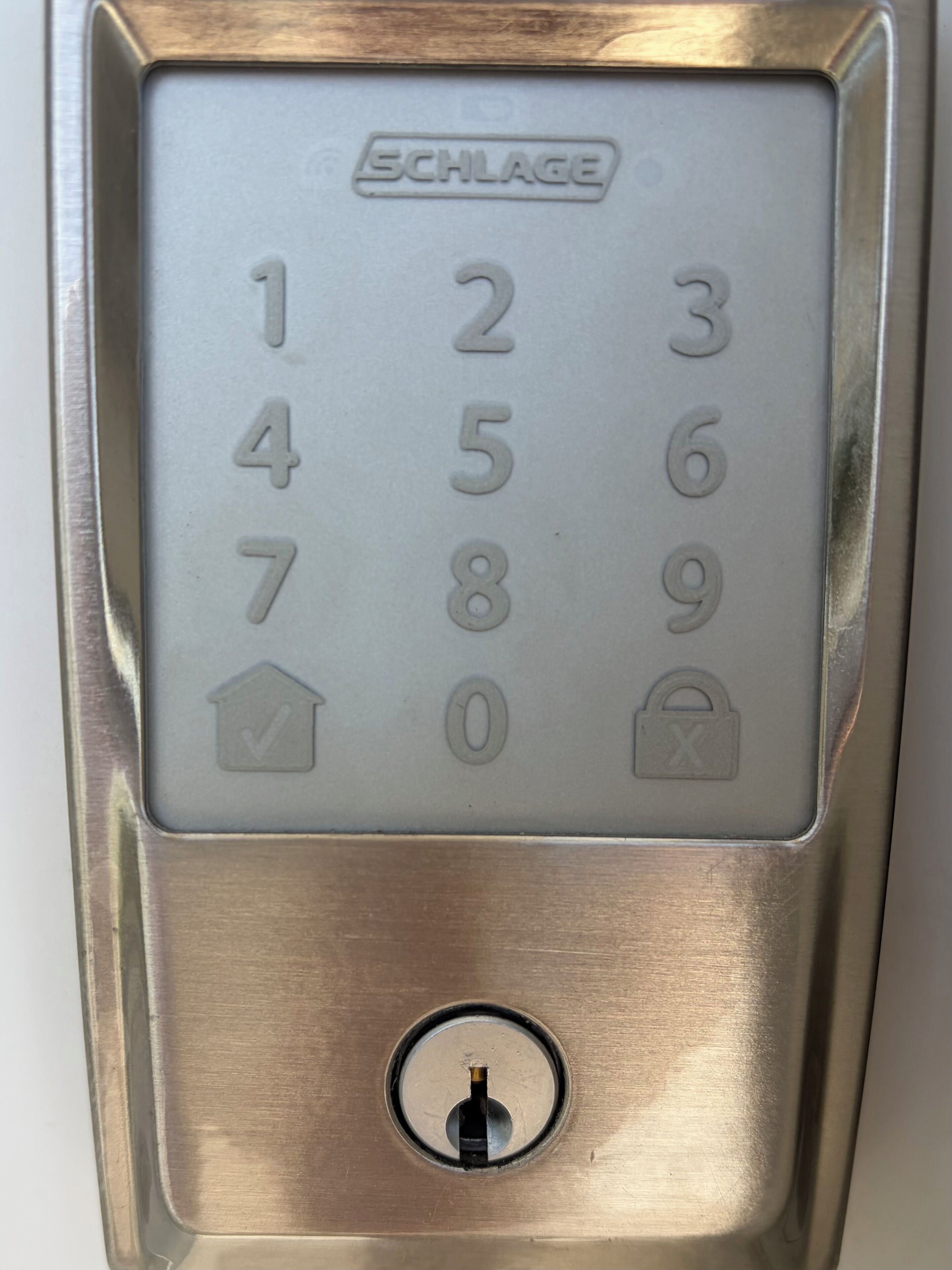 SCHLAGE-merkkinen elektroninen lukko, jossa on numeronäppäimistö ja sen alapuolella perinteinen avaimenreikä.