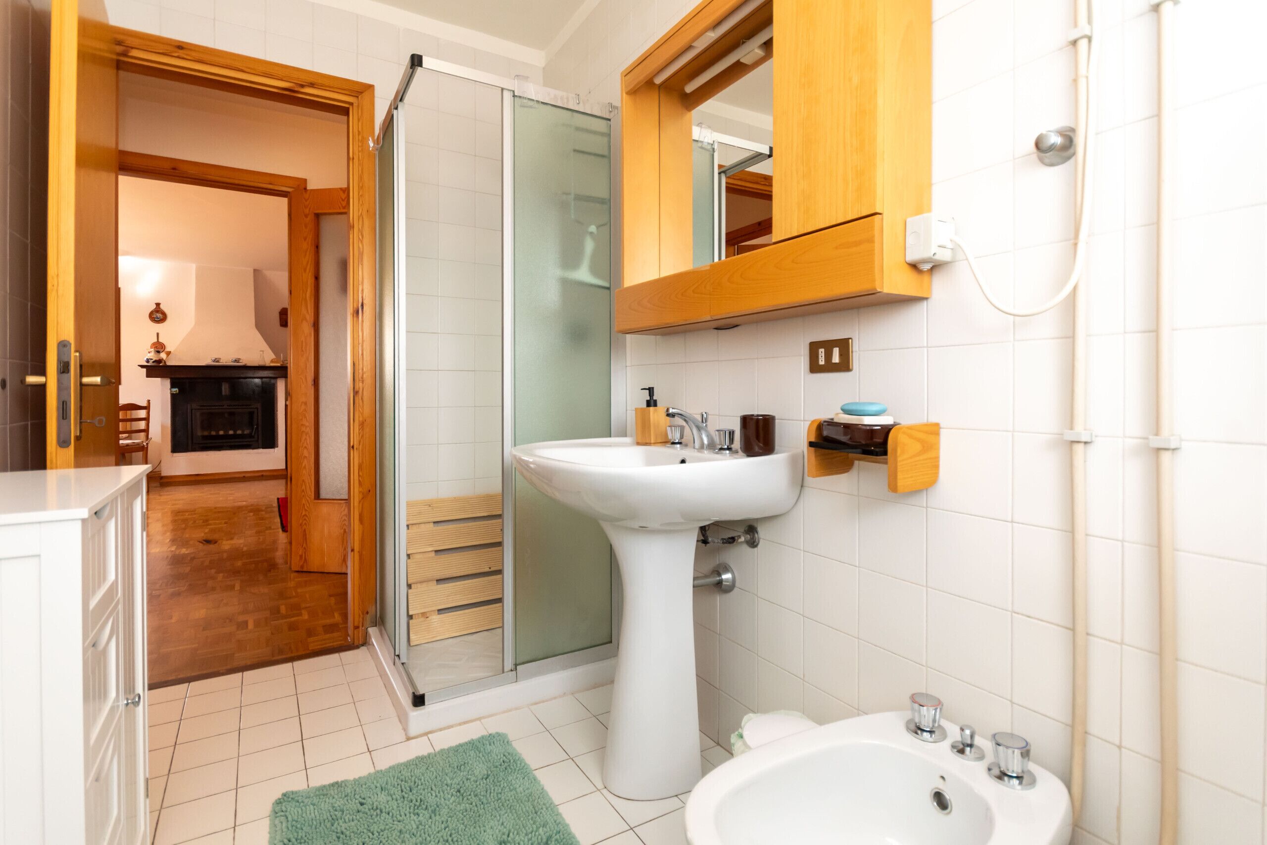 A bathroom with a white sink, a mirror, and a shower.
