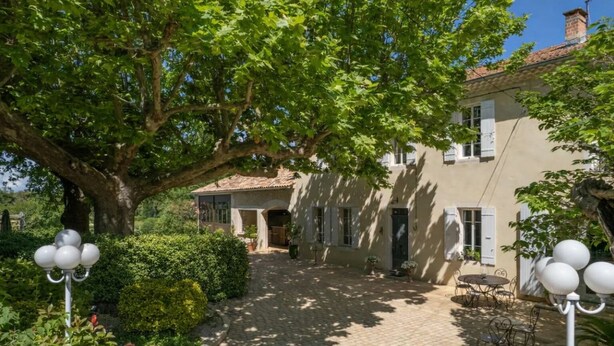 A courtyard with a large tree, a building with a tiled roof, and outdoor seating. - Mas des Trois V - View Vignes & Ventoux - Gîte de Charme Premium 2 to 4 Adults (Sarrians)