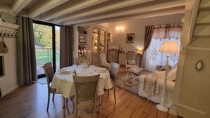 A dining area with a table set for four, a sofa, and a lamp. - Mas des Trois V - View Vignes & Ventoux - Gîte de Charme Premium 2 to 4 Adults (Sarrians)