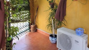 A room with a yellow wall, a white air conditioner, and potted plants. - Apartment With Large Terrace in Almeria (Vera)