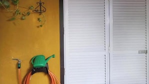 A room with a yellow wall, a white door, and a green watering can. - Apartment With Large Terrace in Almeria (Vera)