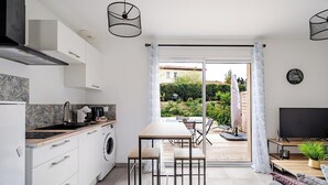 A modern kitchen with a dining area, a sofa, and a TV. - A relaxing break in the countryside, 5 minutes from the sea (Martigues)