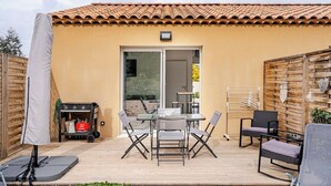 A patio with a table and chairs, a covered area, and a sliding door leading to an interior space. - A relaxing break in the countryside, 5 minutes from the sea (Martigues)