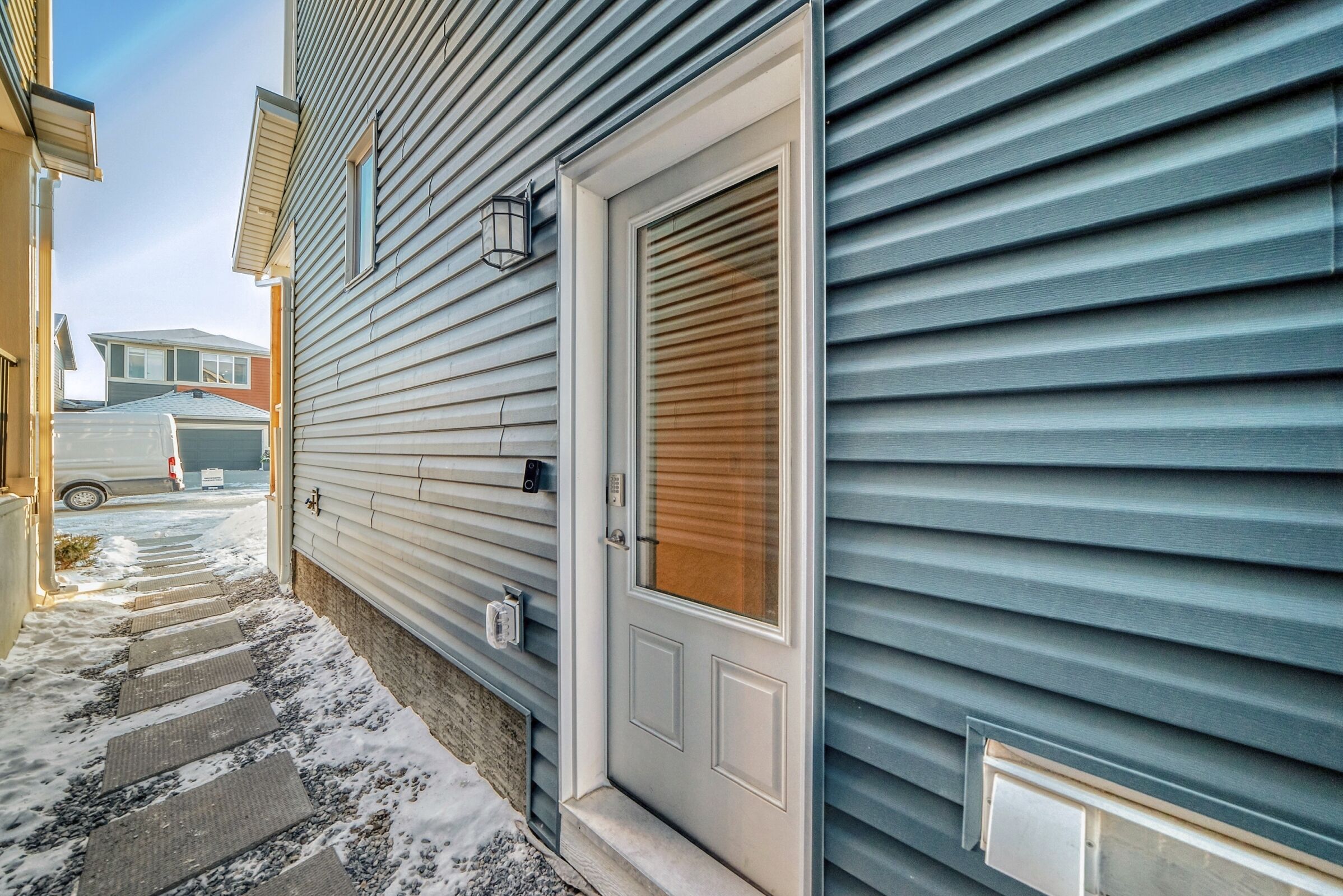 A residential house with a front door, a mailbox, and a garage door.