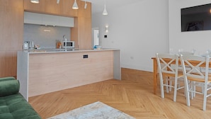 Eine moderne Küche mit Holzschränken, einer zentralen Kochinsel und Pendelleuchten.
