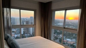 A hotel room with a bed, large windows, and a city view. - Best View in SP - 62 m2 Apartment - 10 min from Butantã Metro Station (Yellow Line) (São Paulo)