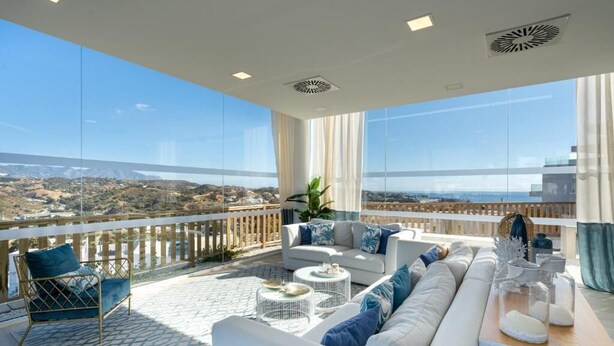 A spacious balcony with a white sofa, a chair, and a coffee table, overlooking a scenic landscape. - Casa Banderas - 2 BR (6p) - Pool view & mountains - La Cala De Mijas (Cala de Mijas)