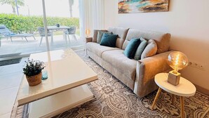 A living room with a sofa, a coffee table, a lamp, and a painting on the wall. - Casa Banderas - 2 BR (6p) - Pool view & mountains - La Cala De Mijas (Cala de Mijas)