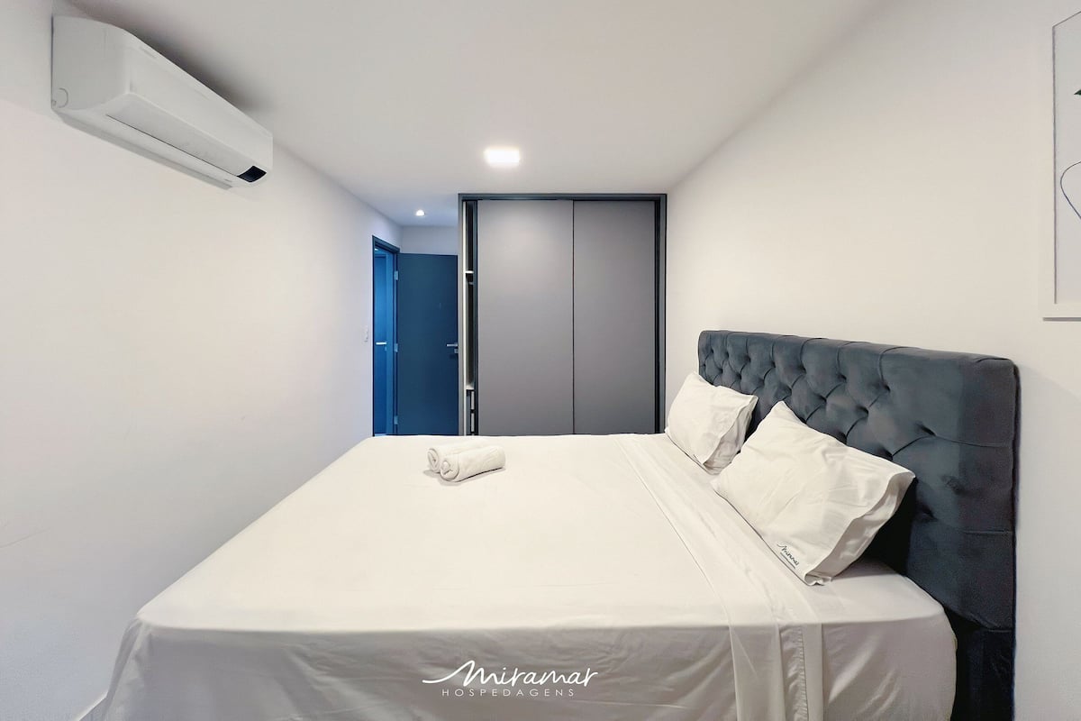 Un dormitorio moderno con cama, armario y equipo de aire acondicionado.