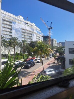 A multi-story hotel with a modern design, a parking lot with several cars, and a construction crane in the background. - Phenomenal Studio - Steps to Beach - Great Views - Historic - terrific stay (Surfside)