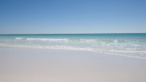 Ein Strand mit blauem Himmel und ruhiger See.
